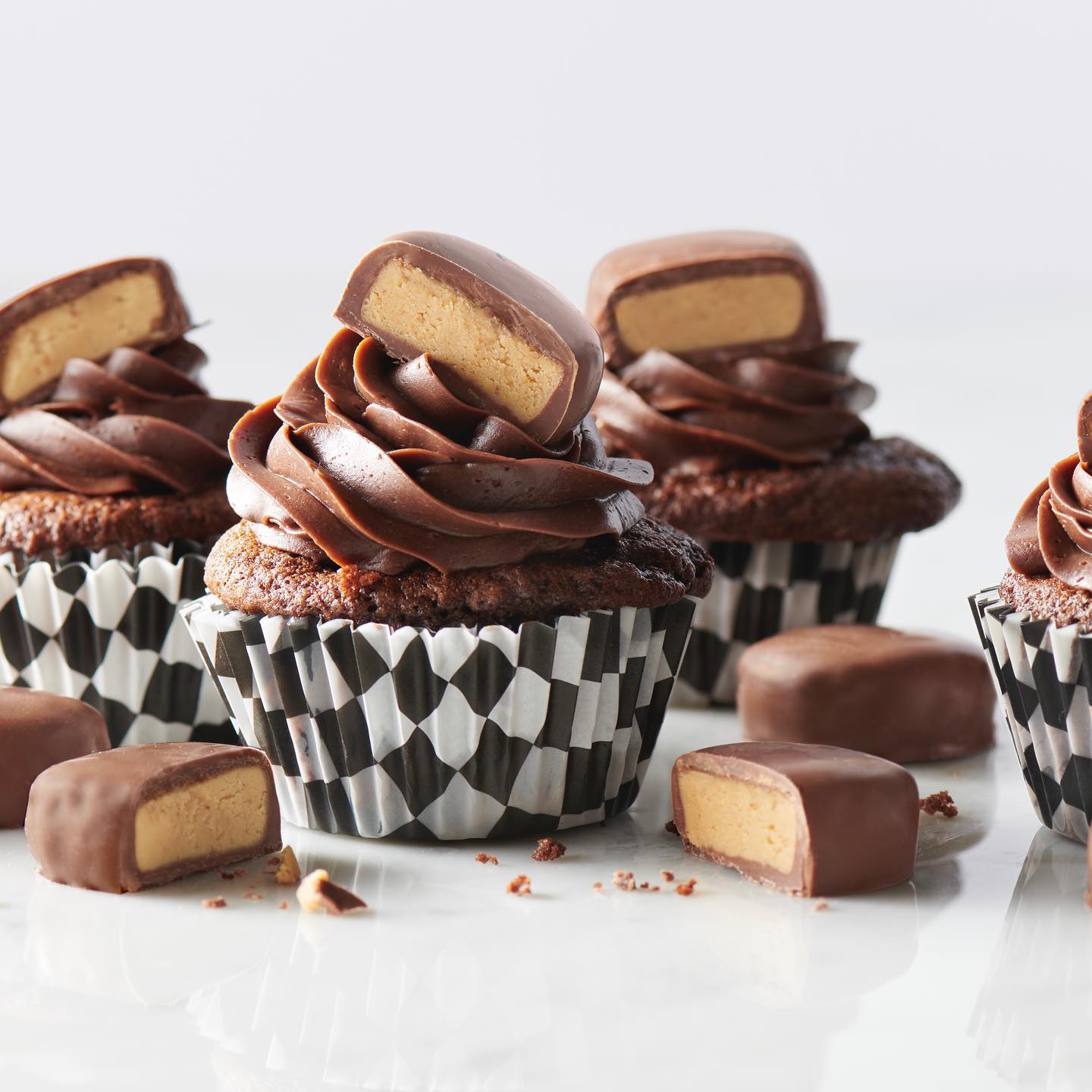 Chocolate cupcakes with See's peanut butter truffles on a white background