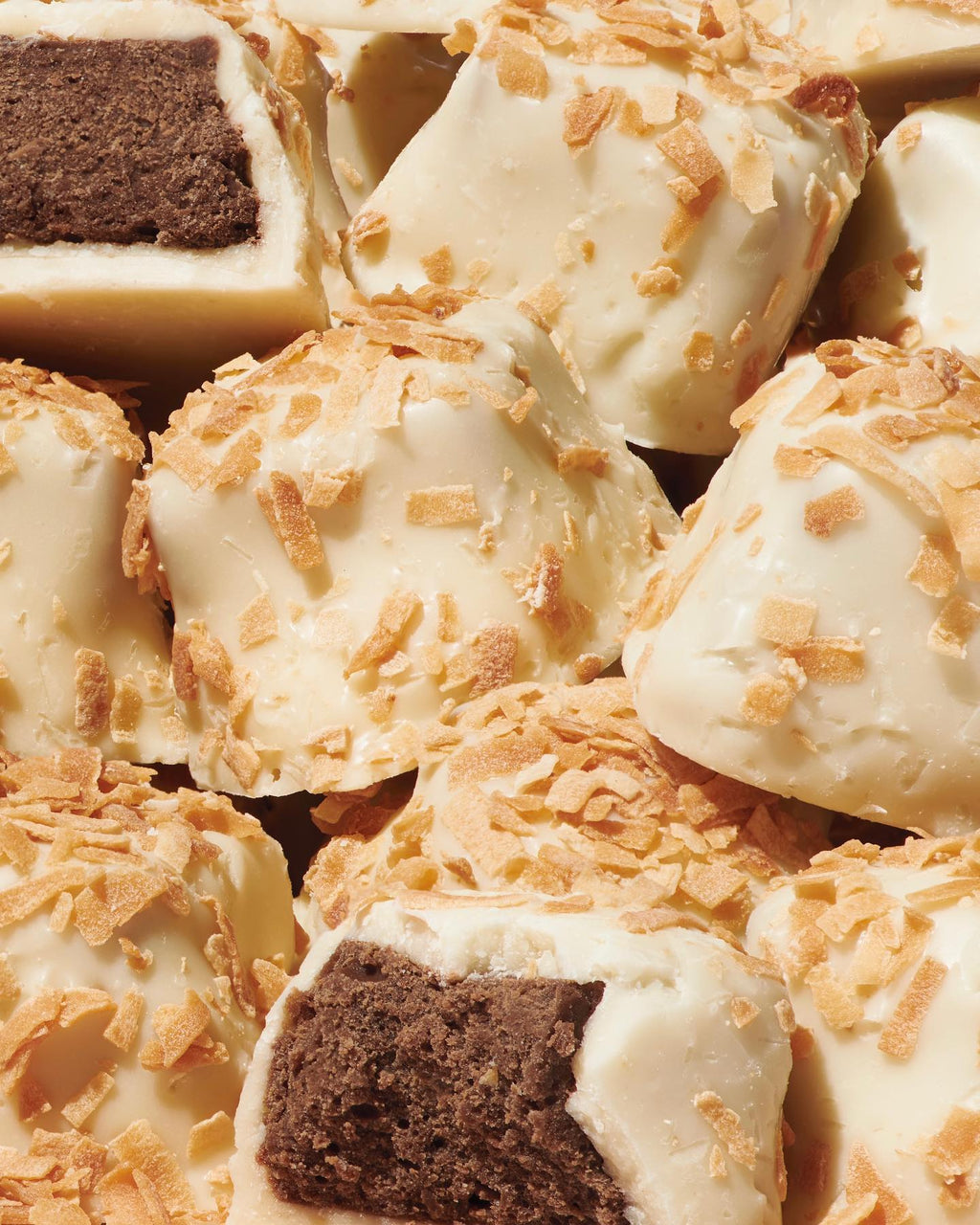 Close-up of kona chocolate truffles with white coating and gold flakes