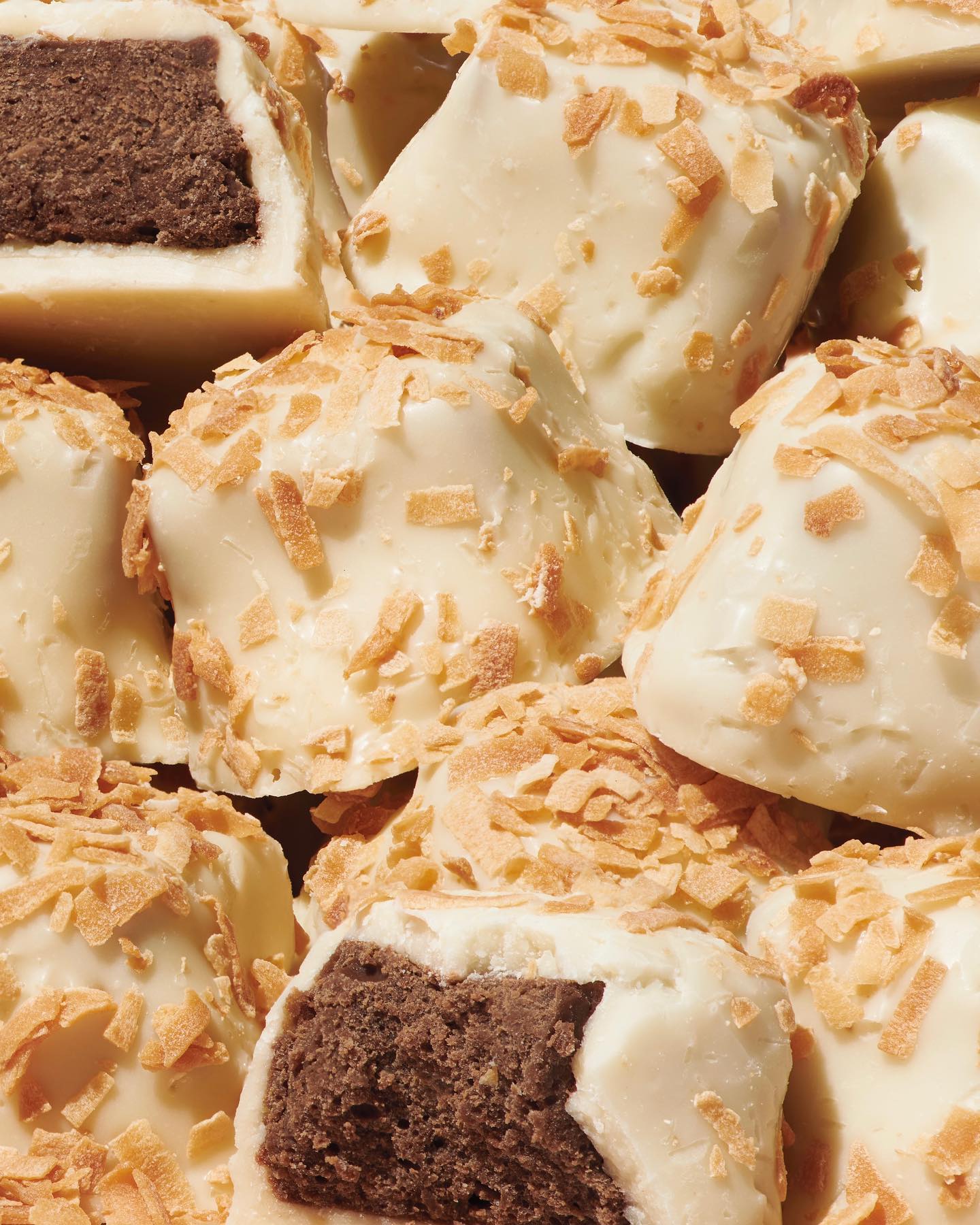 Close-up of kona chocolate truffles with white coating and gold flakes