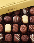 Box of assorted chocolate truffles with a gold lid.
