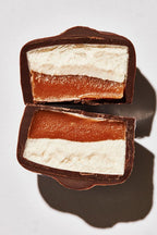 Close-up of a chocolate-covered dark Scotchmallow layered dessert on a white background