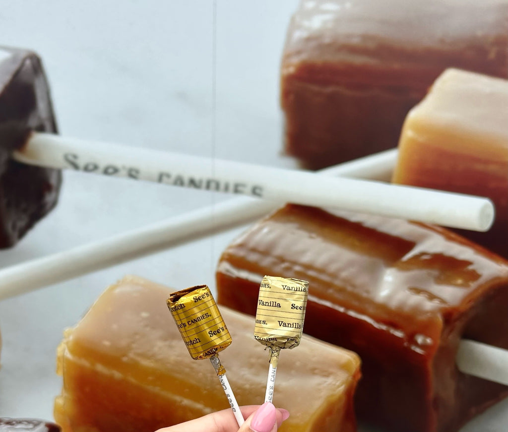 Caramel lollipops with visible brand name on sticks against a blurred background
