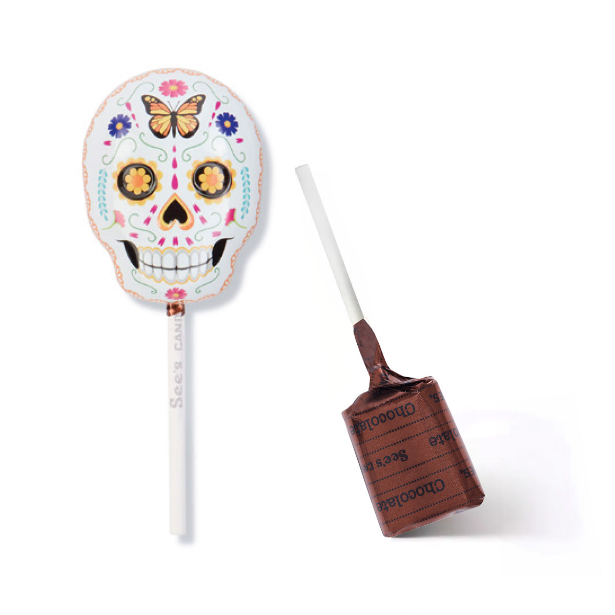 A sugar skull lollipop tin shown on a white background, with one lollipop upright displaying the decorated skull design and the other lying on its side showing the brown chocolate lollypop with wrapper with 'See's Candies' text.