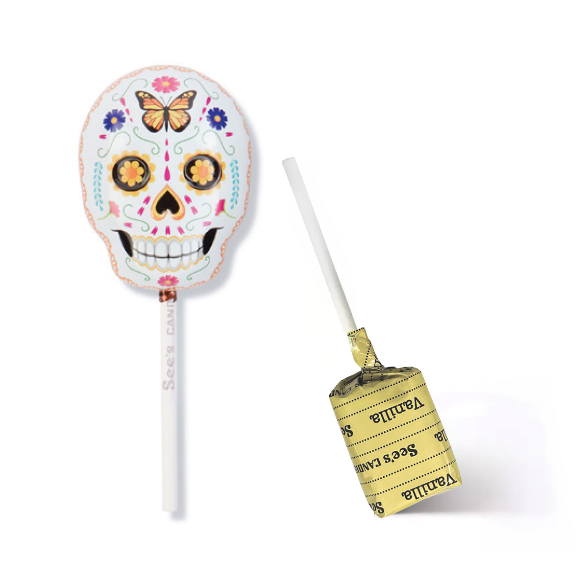 A sugar skull lollipop tin shown on a white background, with one lollipop upright displaying the decorated skull design and the other lying on its side showing the vanilla lollypop with wrapper with 'See's Candies' text.