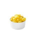 White bowl filled with yellow lemon drops on a white background