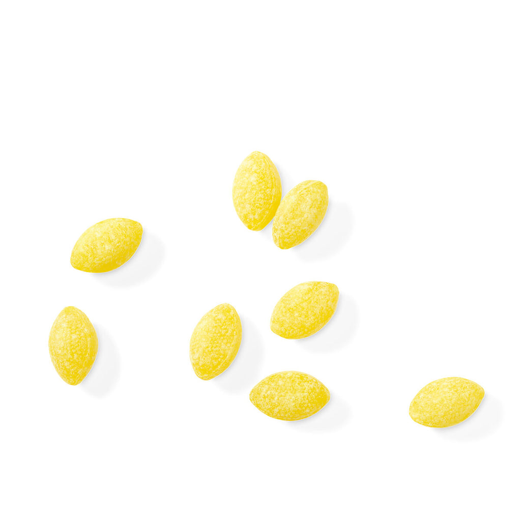 Yellow lemon drops loose on white background