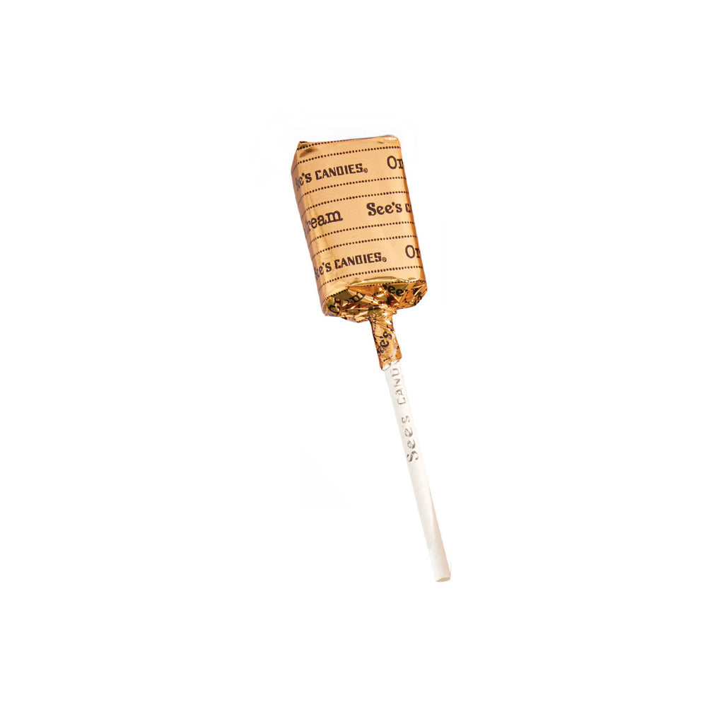 Caramel apple on a stick with See's Candies wrapper on a white background