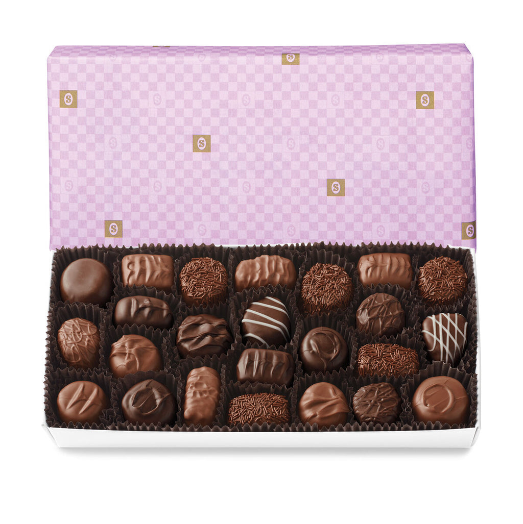 See's soft centres assorted chocolates in a box with a purple checkered lid on a white background