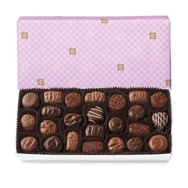 See's soft centres assorted chocolates in a box with a purple checkered lid on a white background