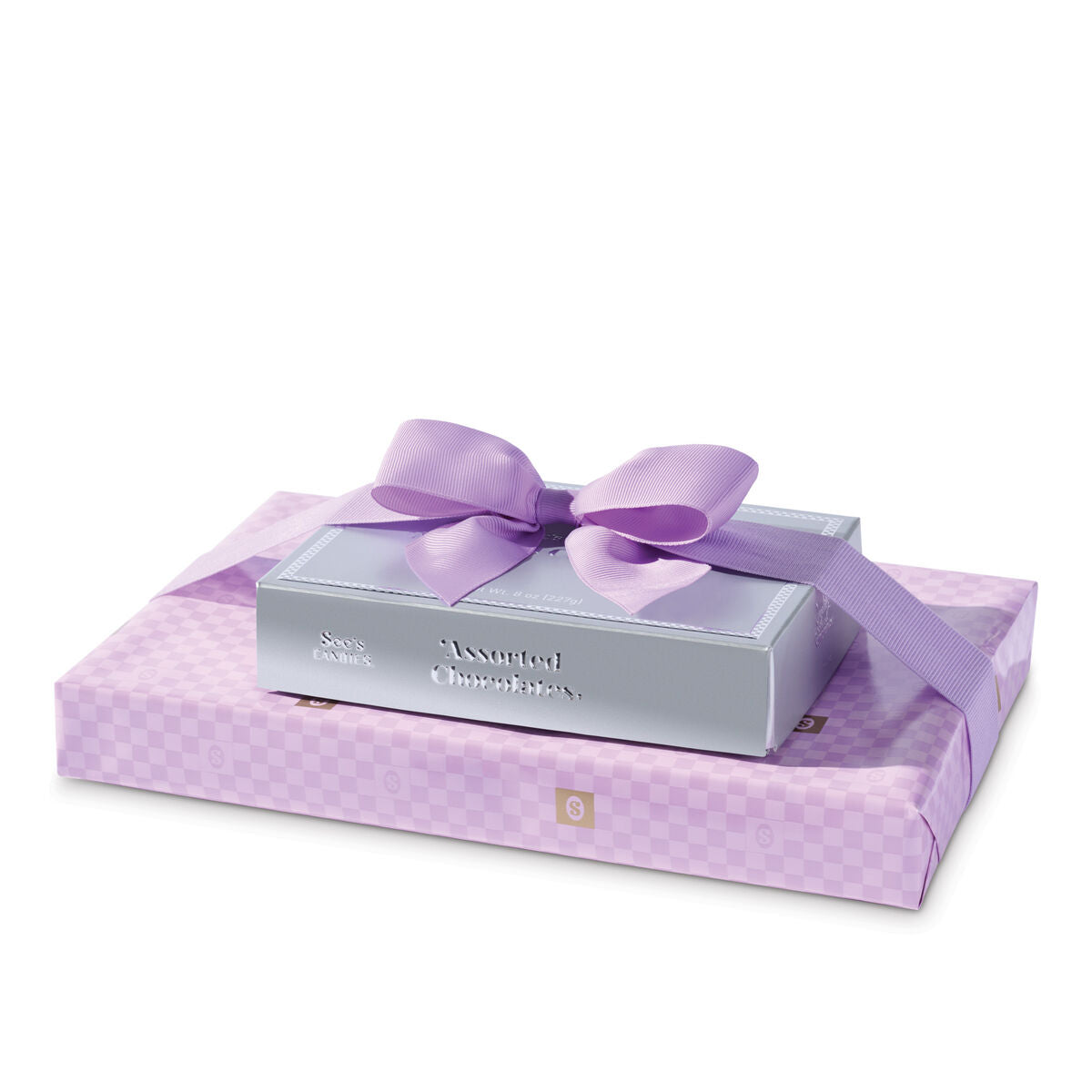 See's silver assorted and 1lb lavender wrapped easter box with a bow on a white background