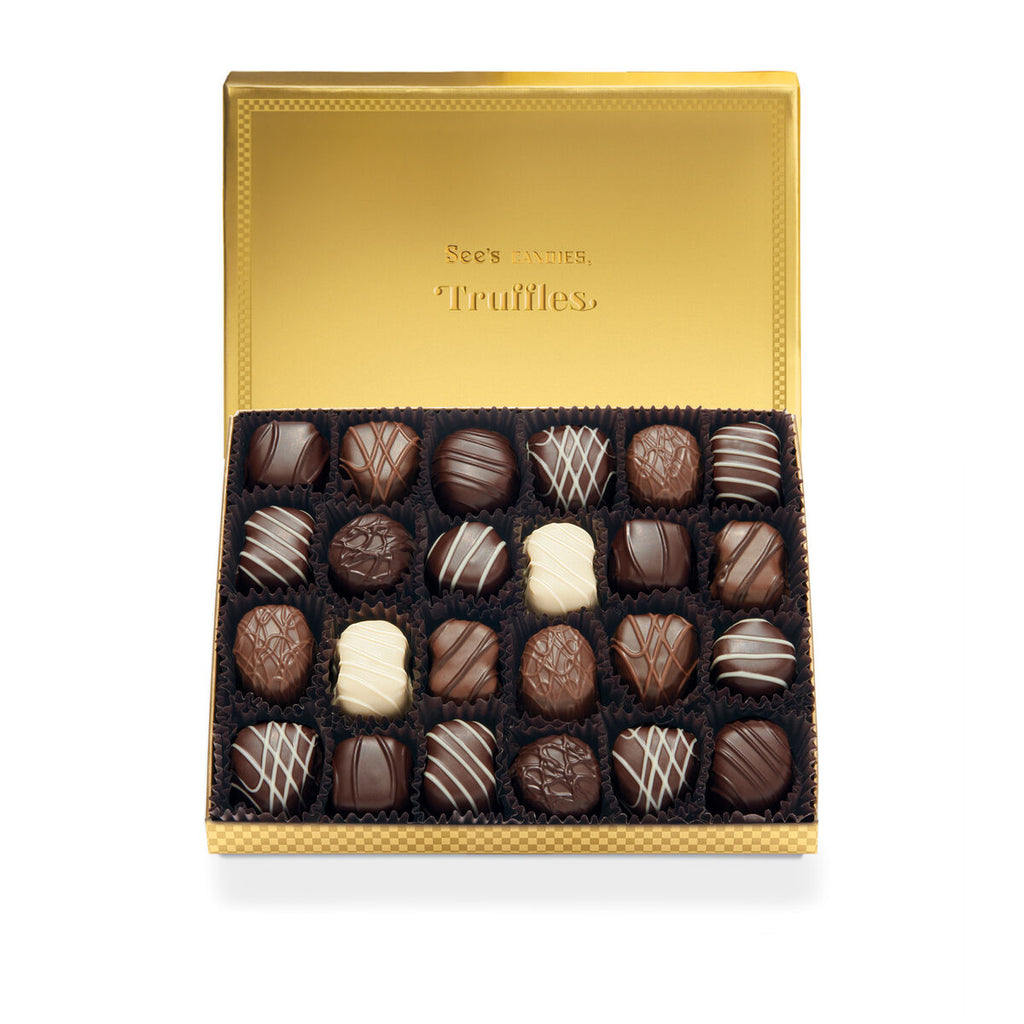 Box of 1lb see's truffles with a gold lid on a white background
